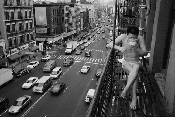 Chien-Chi Chang - USA, A newly arrived immigrant eats noodles on a fire escape, 1998