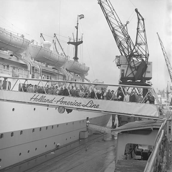 Groep mensen bij de Holland-Amerika Lijn op de gangway boven de Wilhelminakade.